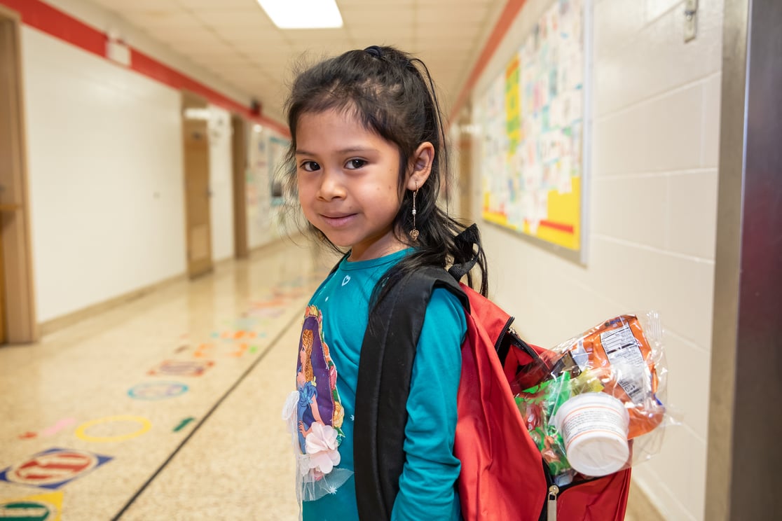 girl smiling with pre-pack in backpack 2